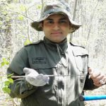 Certified ecologist Tanzeel Farooqi posing with plant specimens in a forest