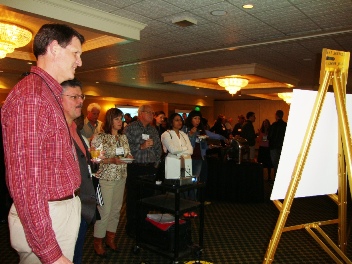 Kurt Fausch of Colorado State looks on while attendees at the conference watch his case study video on fish biodiversity in the Great Plains.