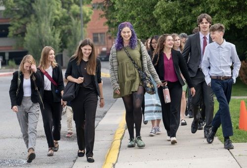 A group of 7 or 8 people walking together down a sidewalk.