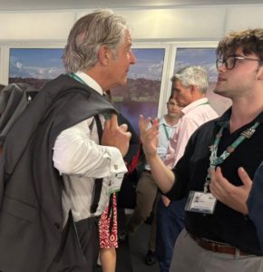 Tony Juniper and ESA delegate David Baldwin standing and looking at each other while discussing Baldwin’s new book at COP16 conference.