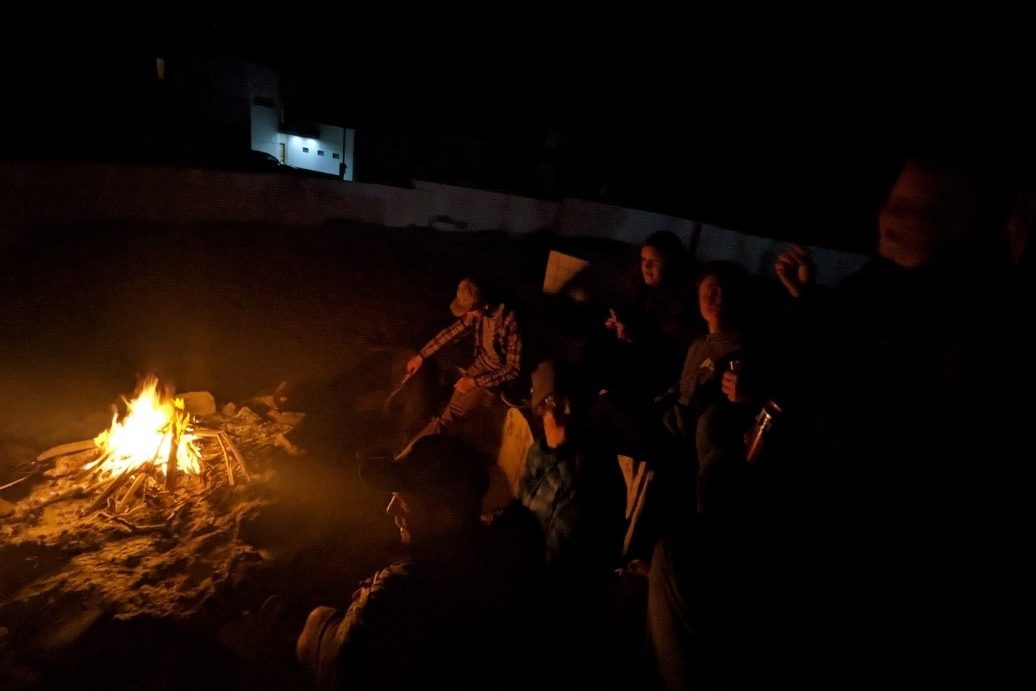 A bonfire with some people standing around.