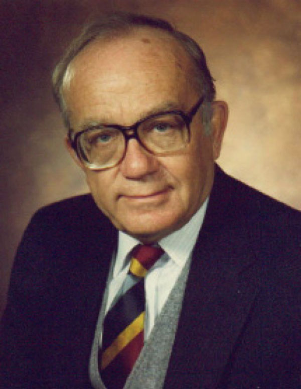 Profile image of Stanley Auerbach in a coat and tie.