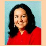 Portrait of Dr. Robin Kimmerer in a red blouse on a blue background.