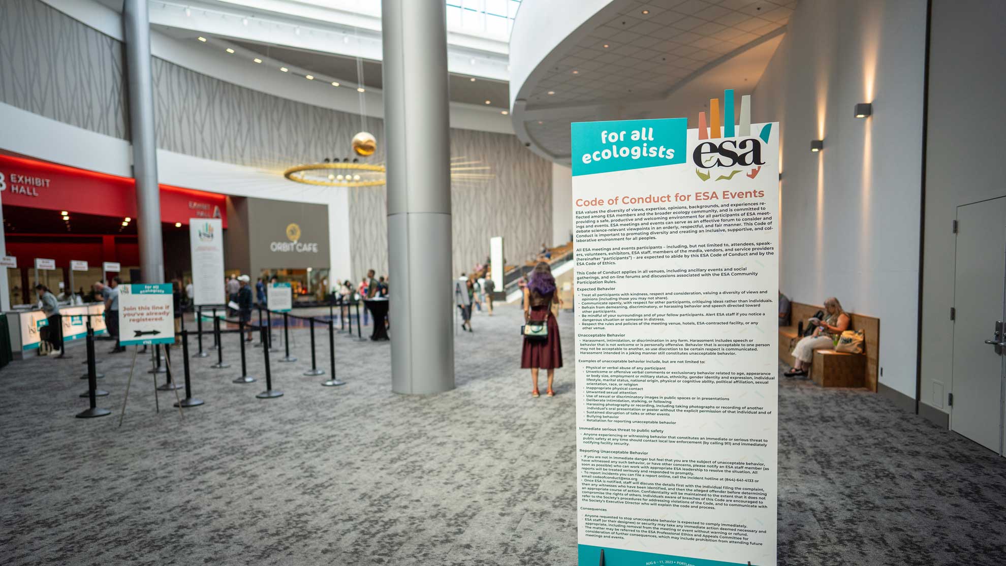 A banner at from the 2023 Annual Meeting displays the code of conduct written.