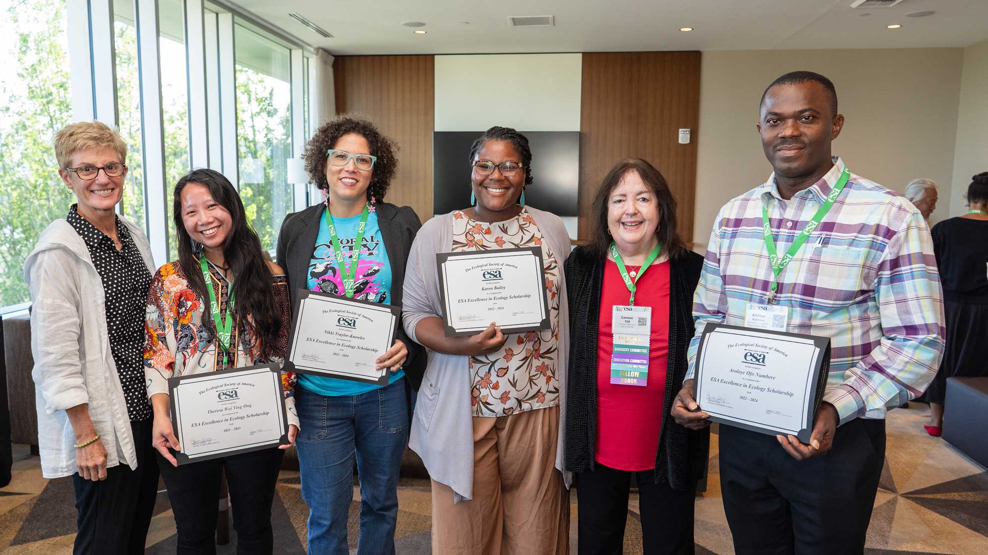 Six people pose with awards in hand.