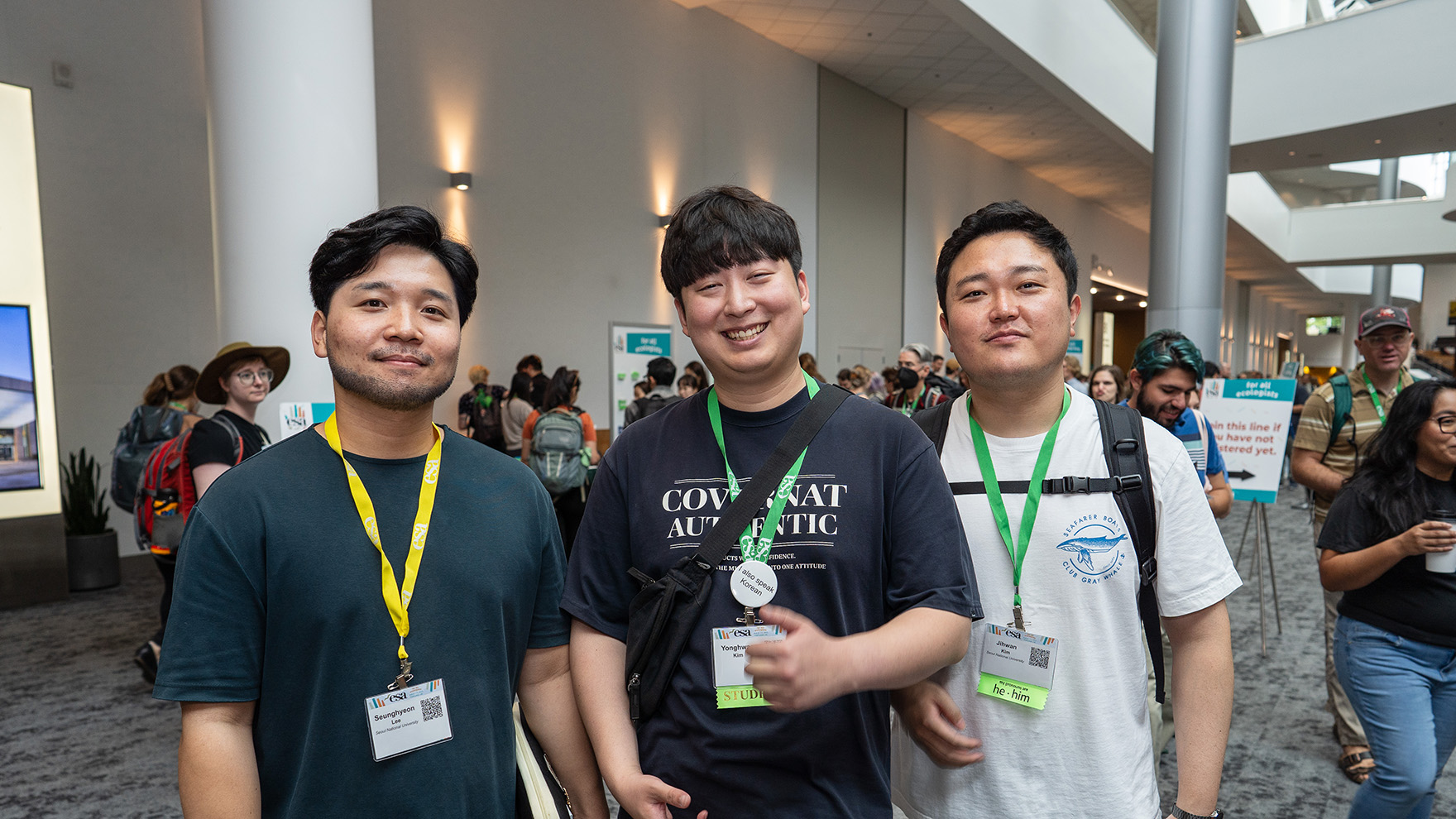 Three participants smile for the camera in between sessions at the 2023 meeting.