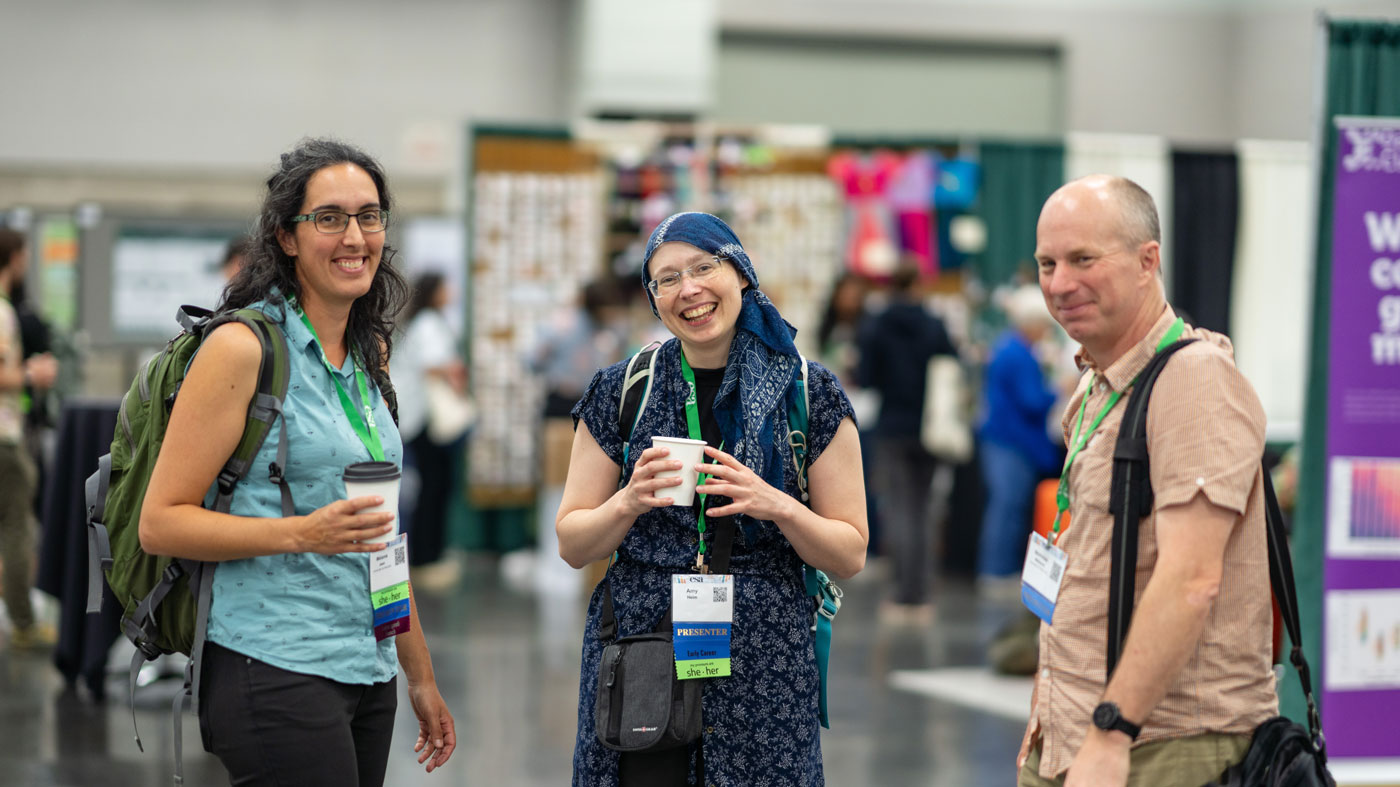 Three presenters converse over tea and coffee.