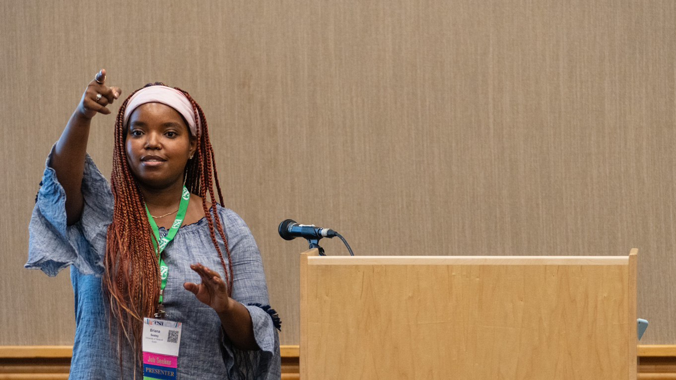 A speaker addresses the audience she presents in front of.