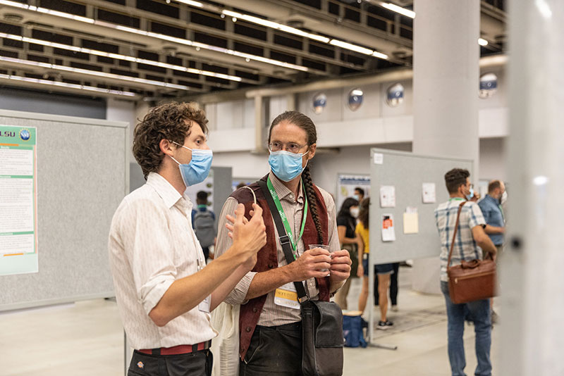 Two attendees discuss a poster.