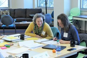 Two participants enjoy a conversation while seated at a table together during a strategies for success meeting.